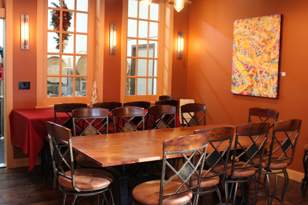 The tasting room is furnished with repurposed printing press tables and Italian sewing machine stools