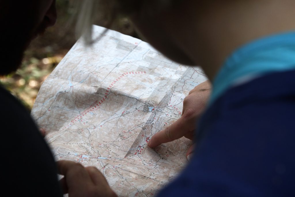 image of two people pointing at a spot on a paper map